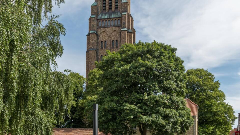A church with a tall spire and a clock.