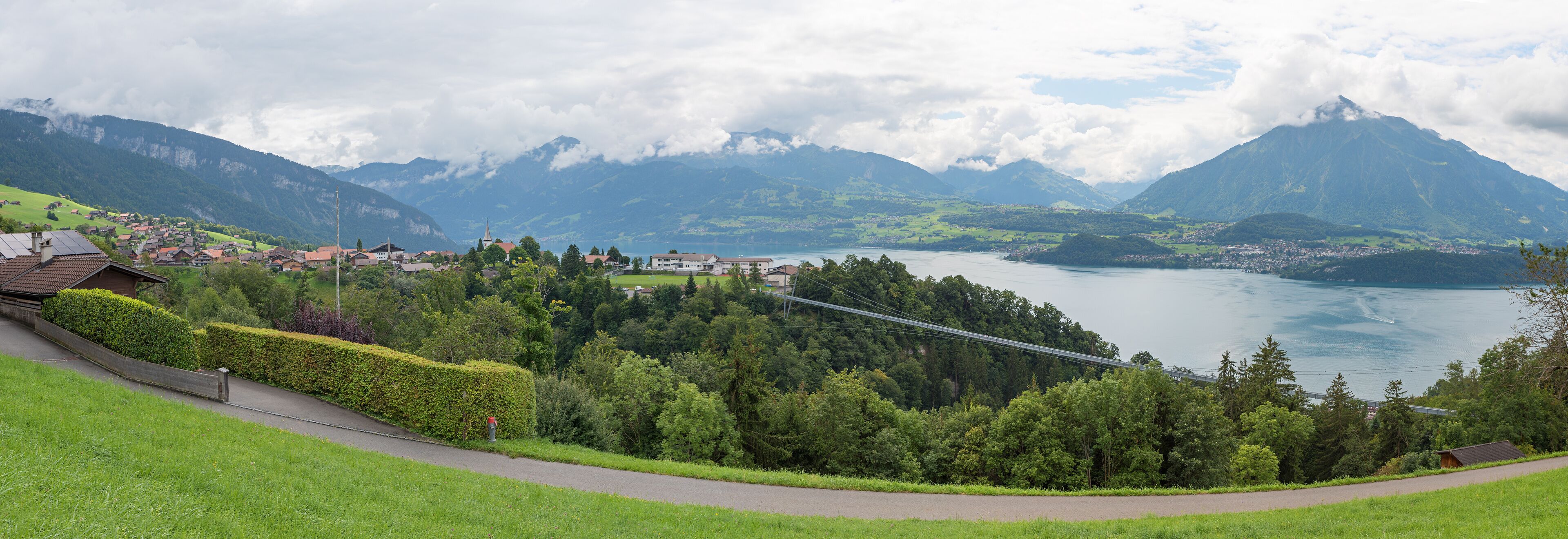A mountainous landscape with a lake, a bridge, and a village.