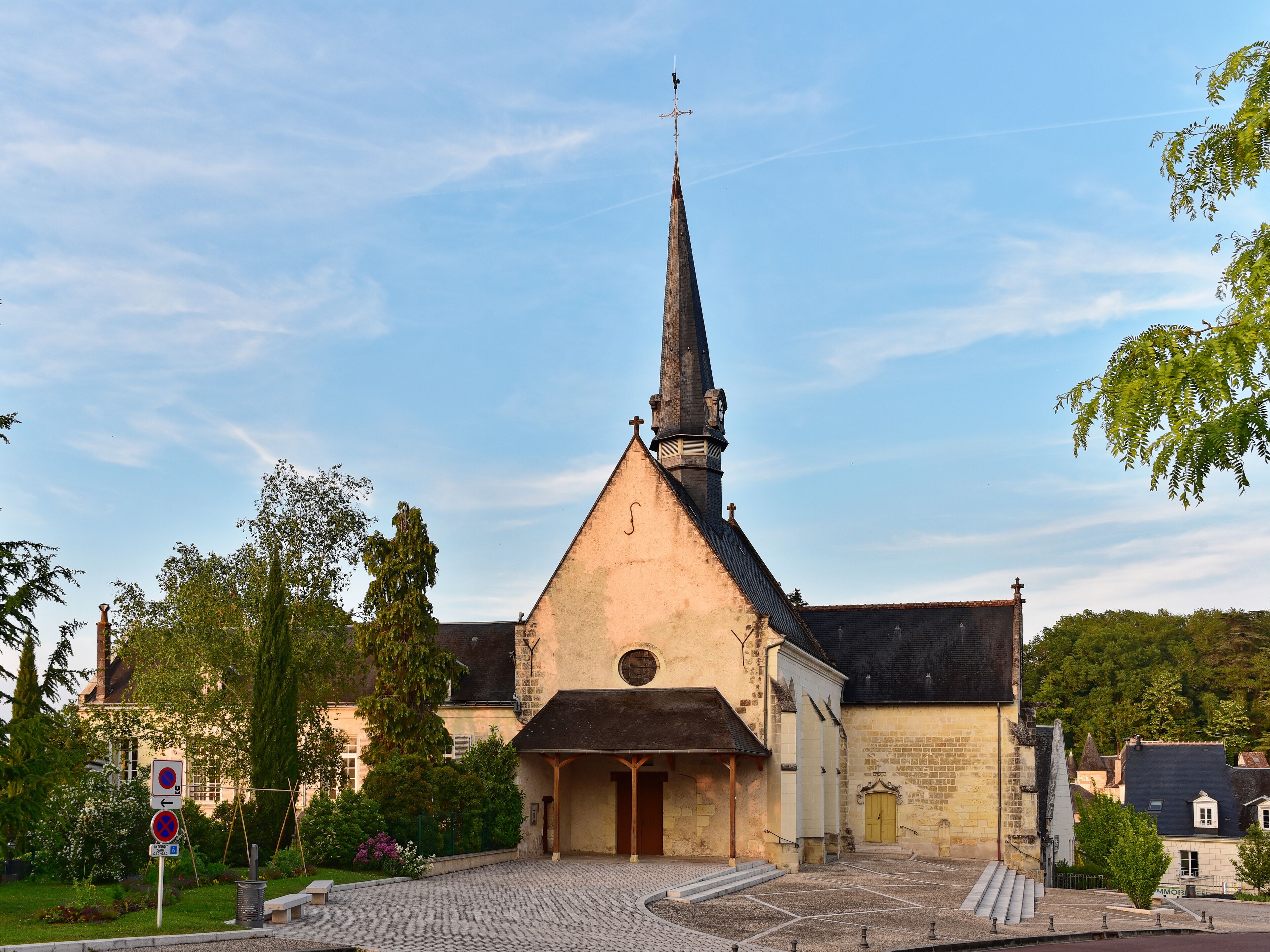 A church with a tall steeple and a clock.