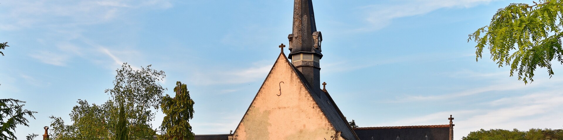 A church with a tall steeple and a clock.