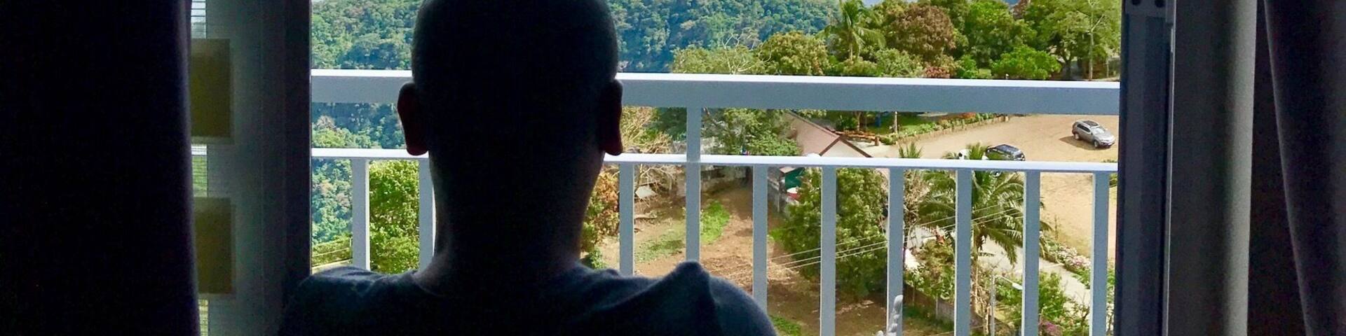 A person overlooking a scenic view of a coastline with mountains and a body of water.