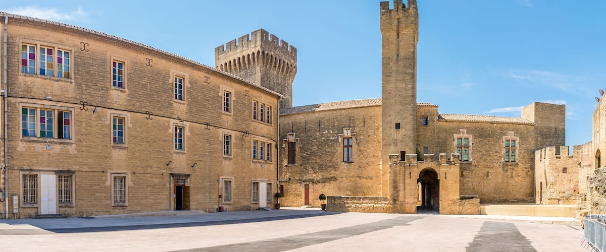 A historic building with a tall tower and a flag.