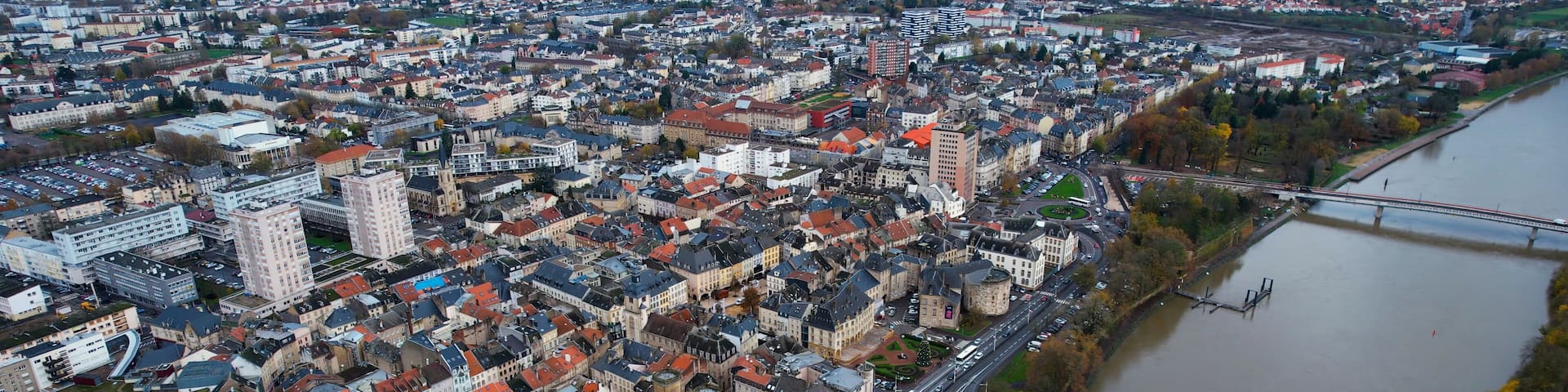 A river flowing through a densely built city with a prominent bridge and historic buildings.