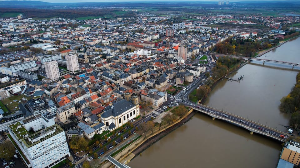 A river flowing through a densely built city with a prominent bridge and historic buildings.