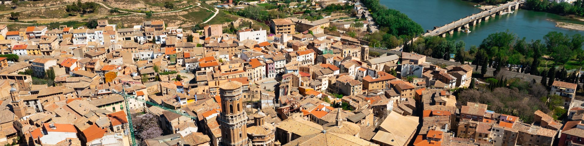 A densely packed urban area with historic architecture, a prominent church tower, and a river running through the city.