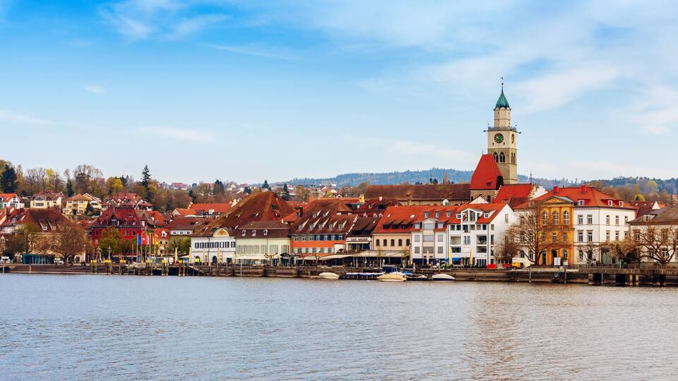 A riverside town with historic buildings and a prominent clock tower.