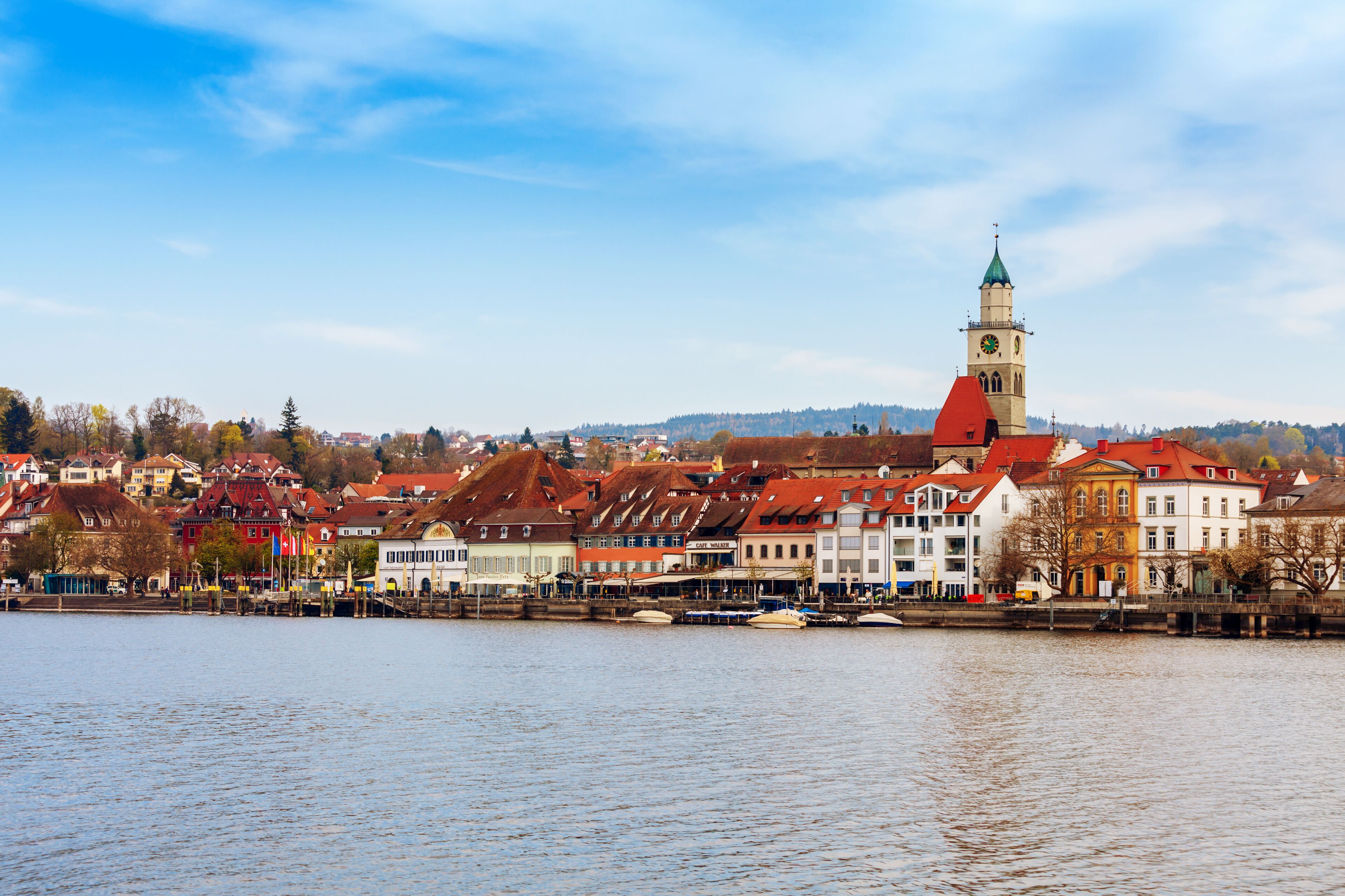 A riverside town with historic buildings and a prominent clock tower.