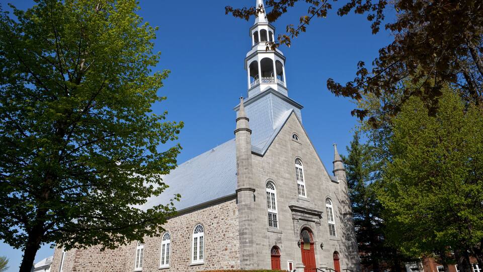 A historic church with a tall steeple and a red door.