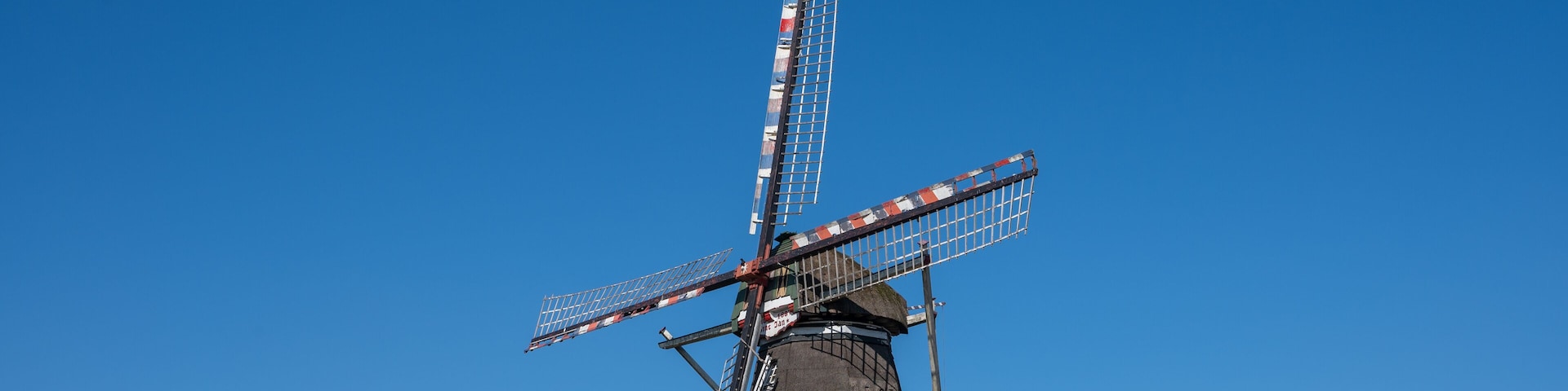 A traditional windmill with a clear blue sky in the background.
