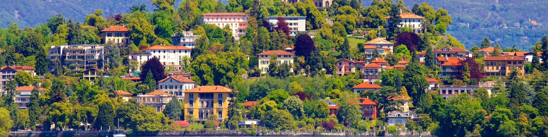 Verbania showing a small town or village, a lake or waterhole and mountains