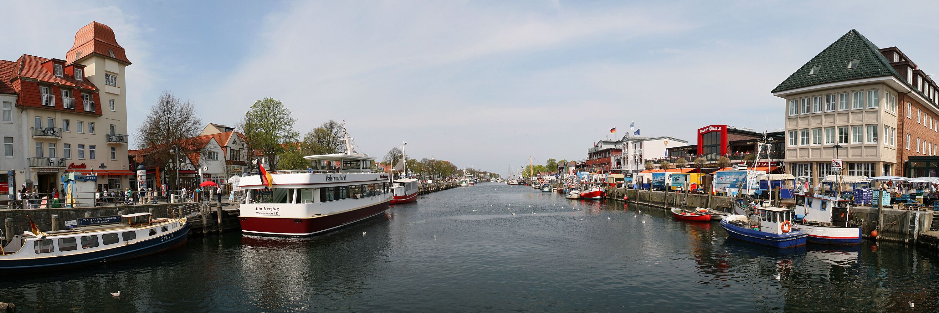 A canal with boats, buildings, and a clear sky.