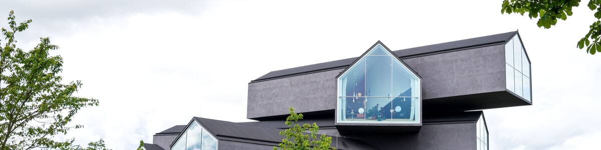 Ein modernes Gebäude mit großen Fenstern und einem markanten architektonischen Design.