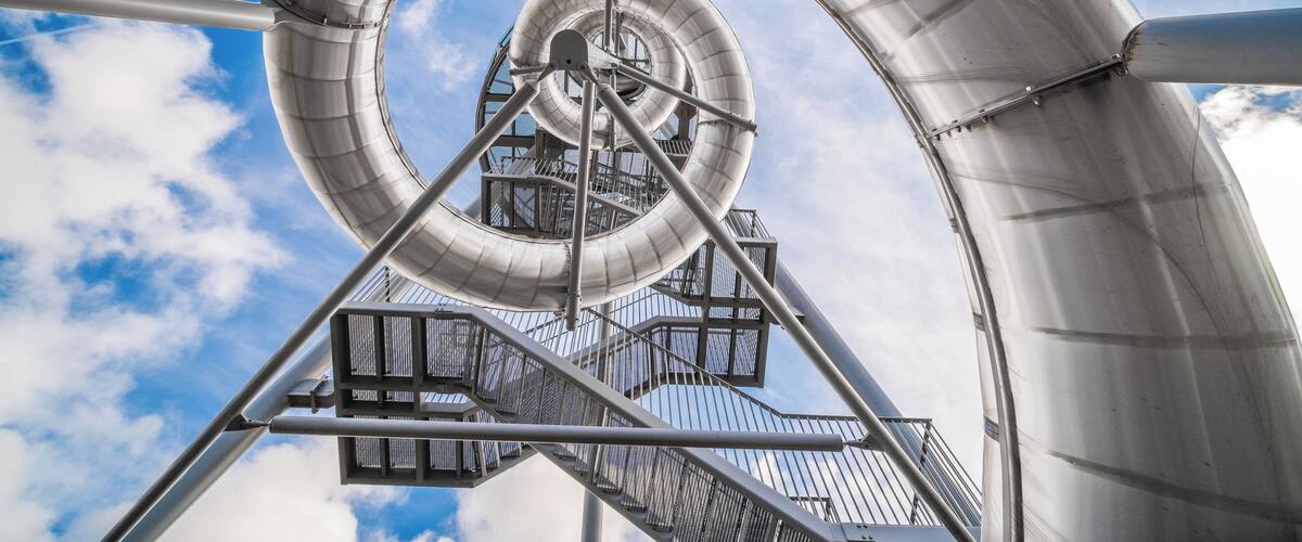 A spiral structure against a blue sky with clouds.