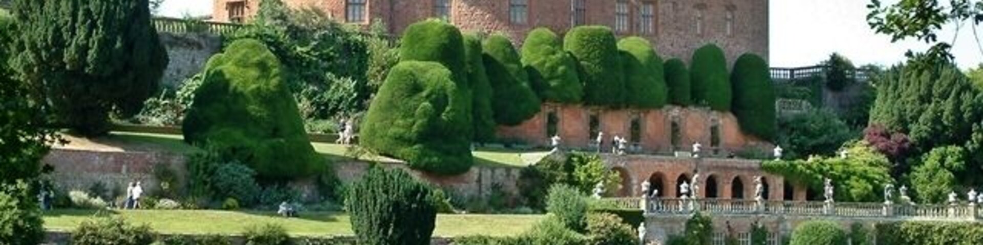 Un castillo con un jardín cuidado y un puente.