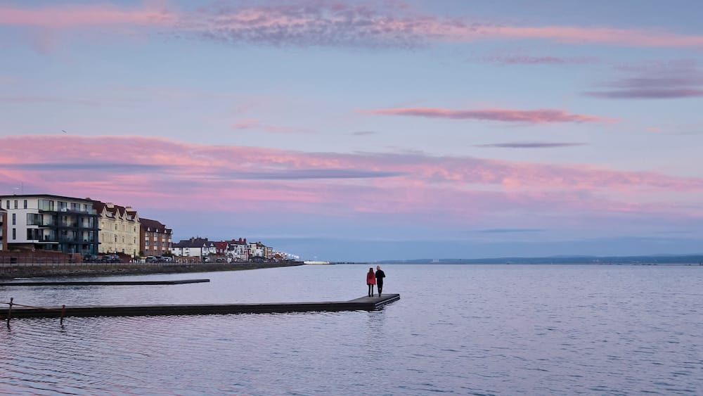 A waterfront with buildings and a pier.