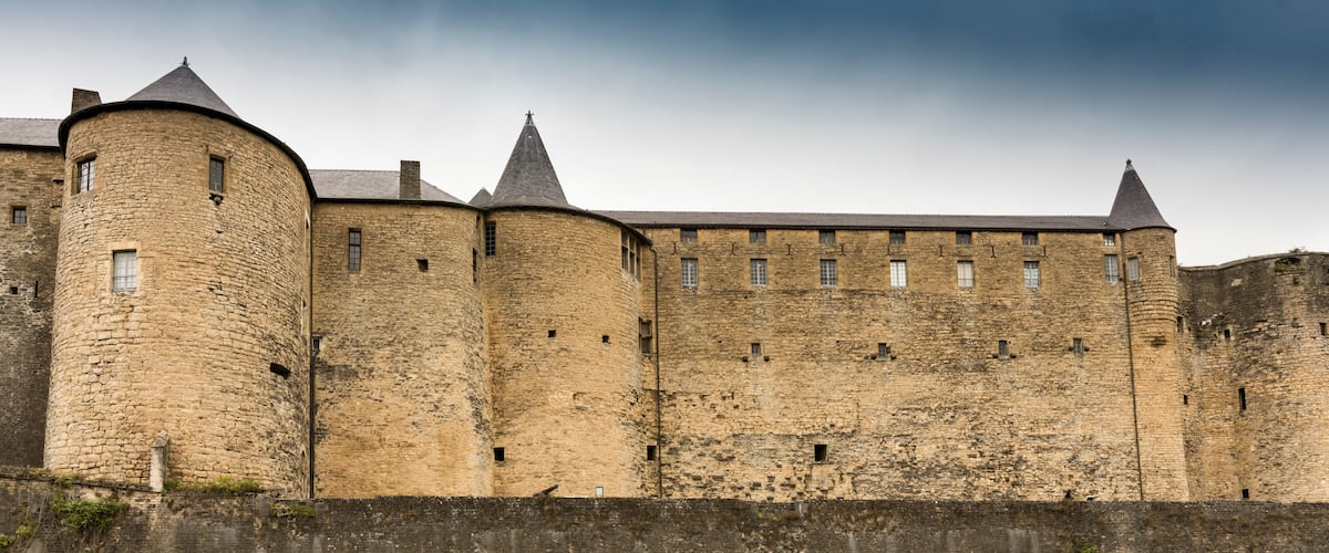 A medieval castle with stone walls and multiple towers.