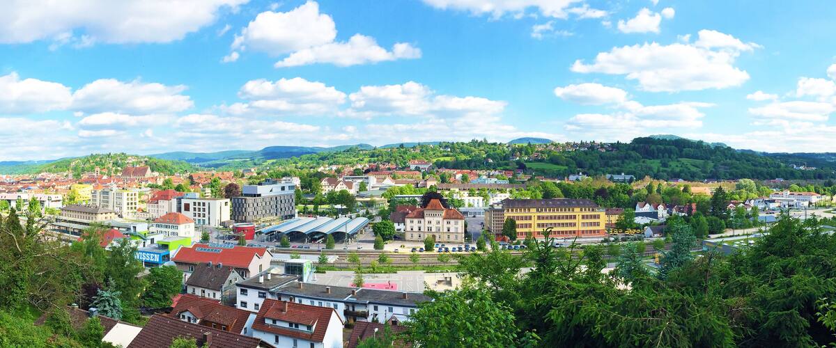 A town with a train station, buildings, and a hill in the background.