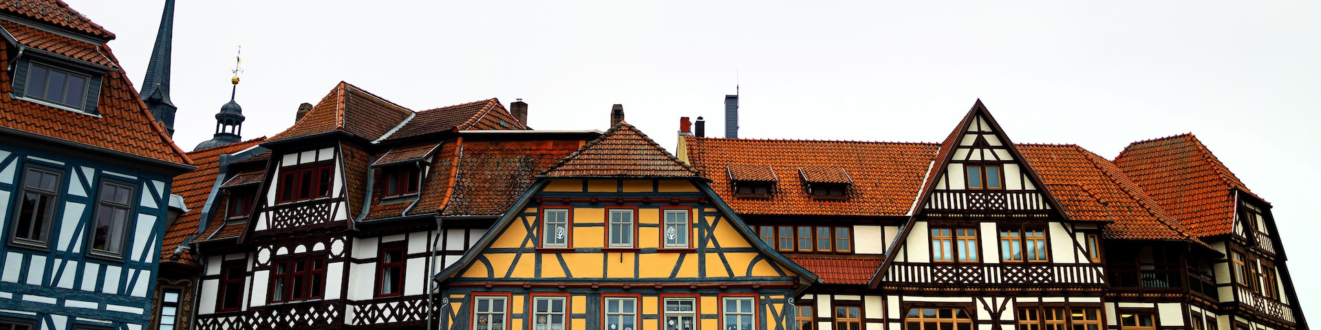 Uma fileira de casas tradicionais em estilo enxaimel, com telhados vermelhos e fachadas brancas.