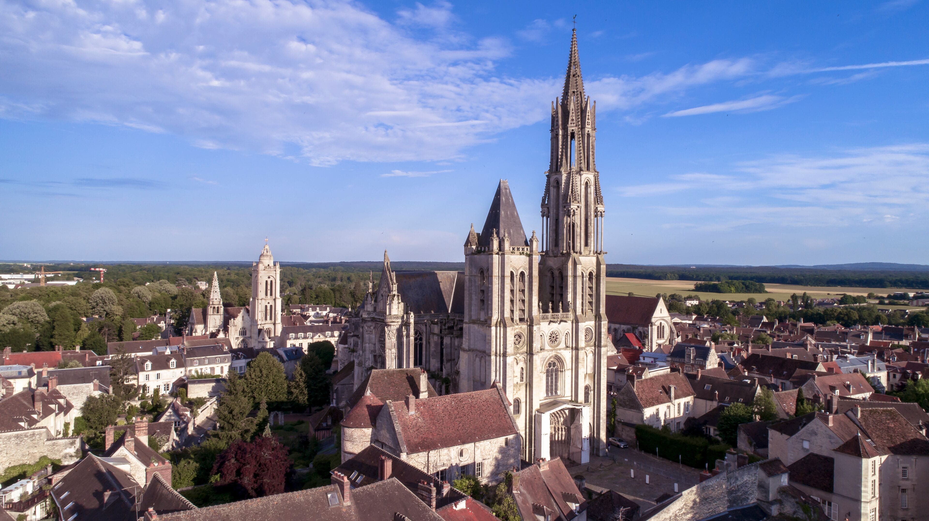 A historic cathedral with twin spires, surrounded by a town with traditional architecture.