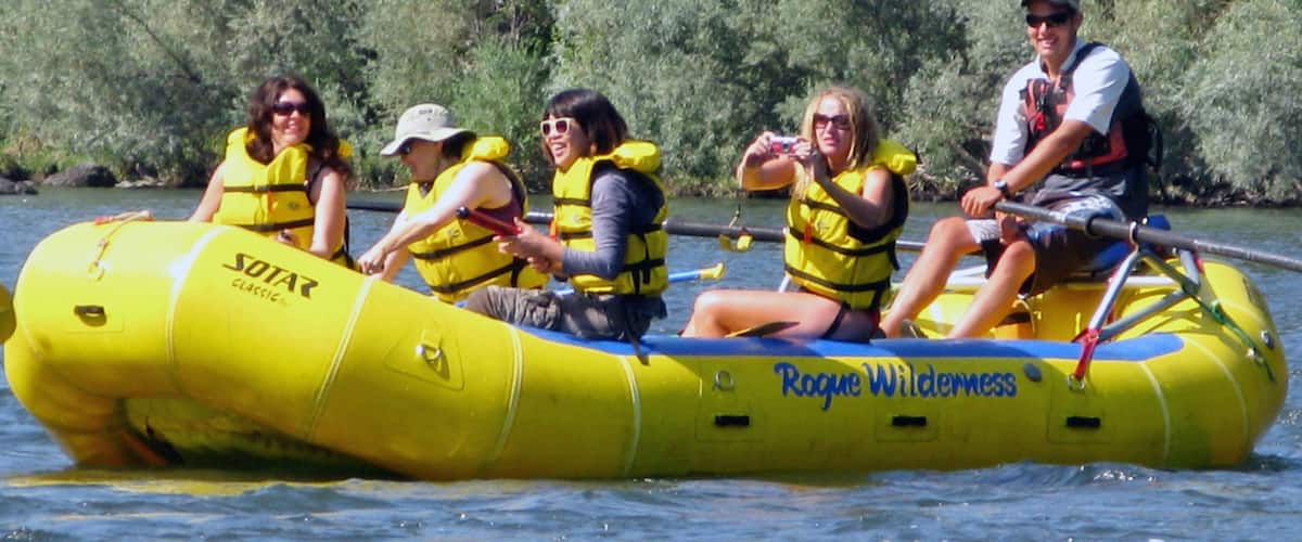 A group of people in a yellow inflatable raft on a river.