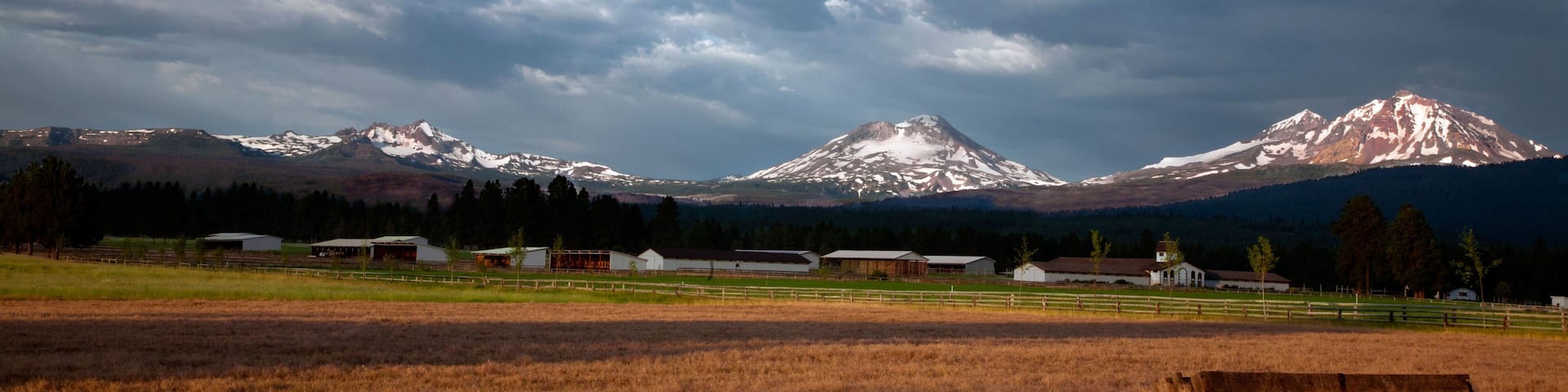 DJ0XNN OREGON - Farm at the town of Sisters with the Three Sisters and Broken Top Mountains beyond.