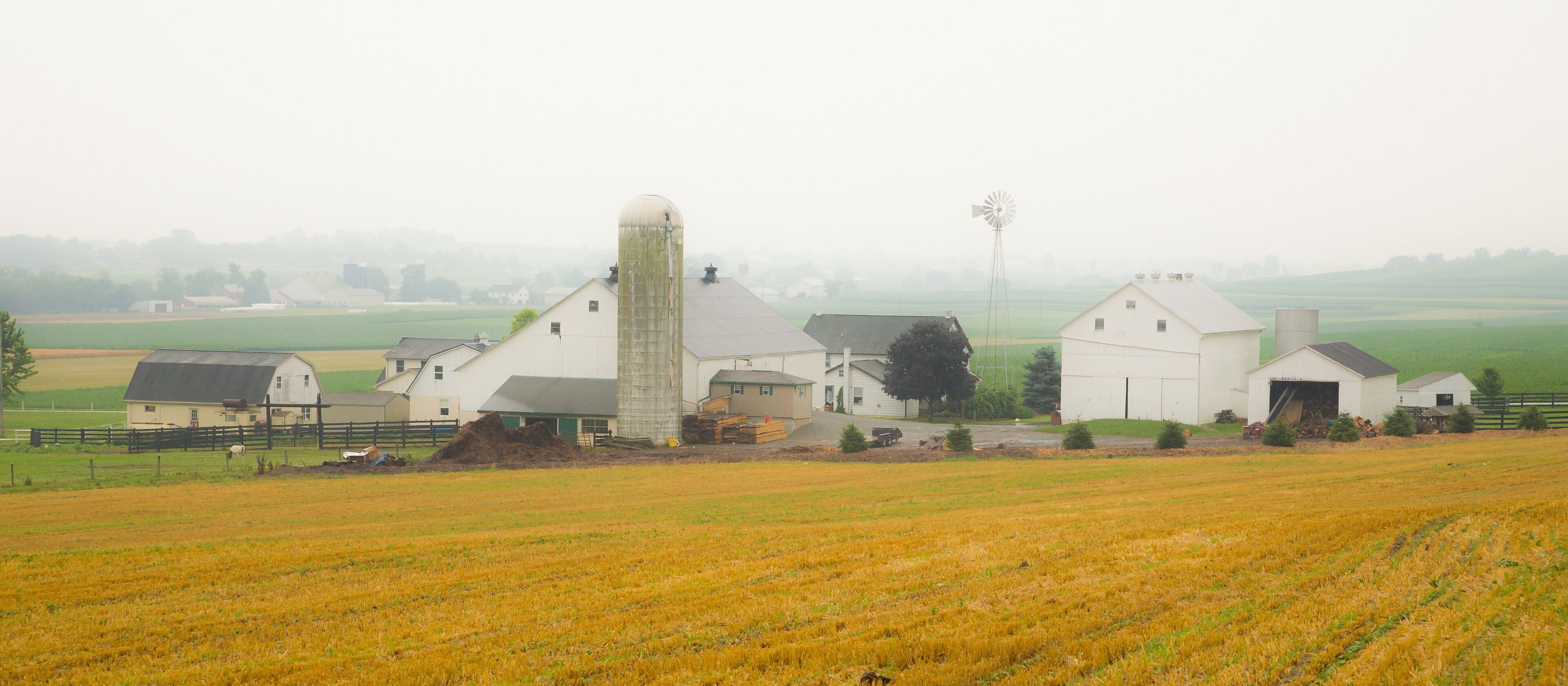 Amish farm with barn and agriculture fields in foreground near Intercourse, Pennsylvania.