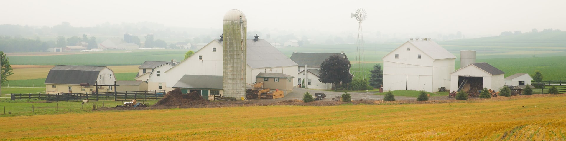 A rural farm with barns and a silo.