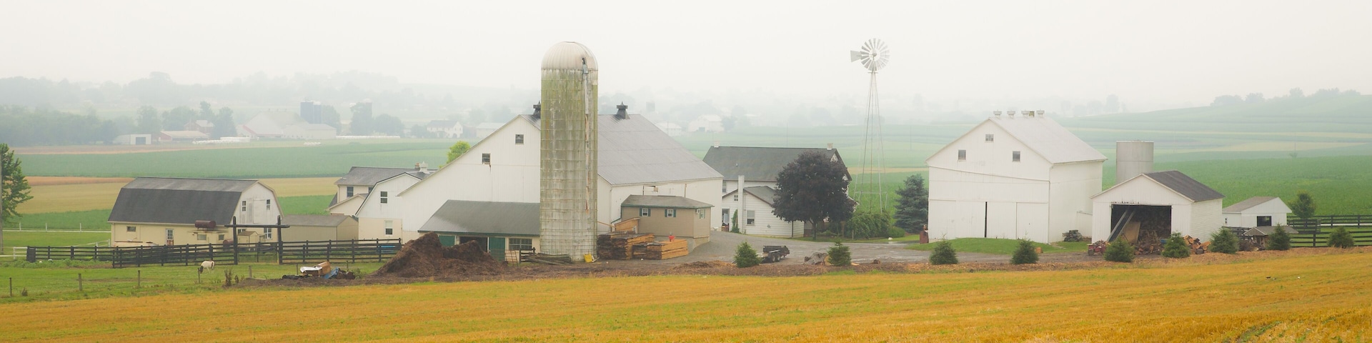 Una granja rural con graneros y un silo.