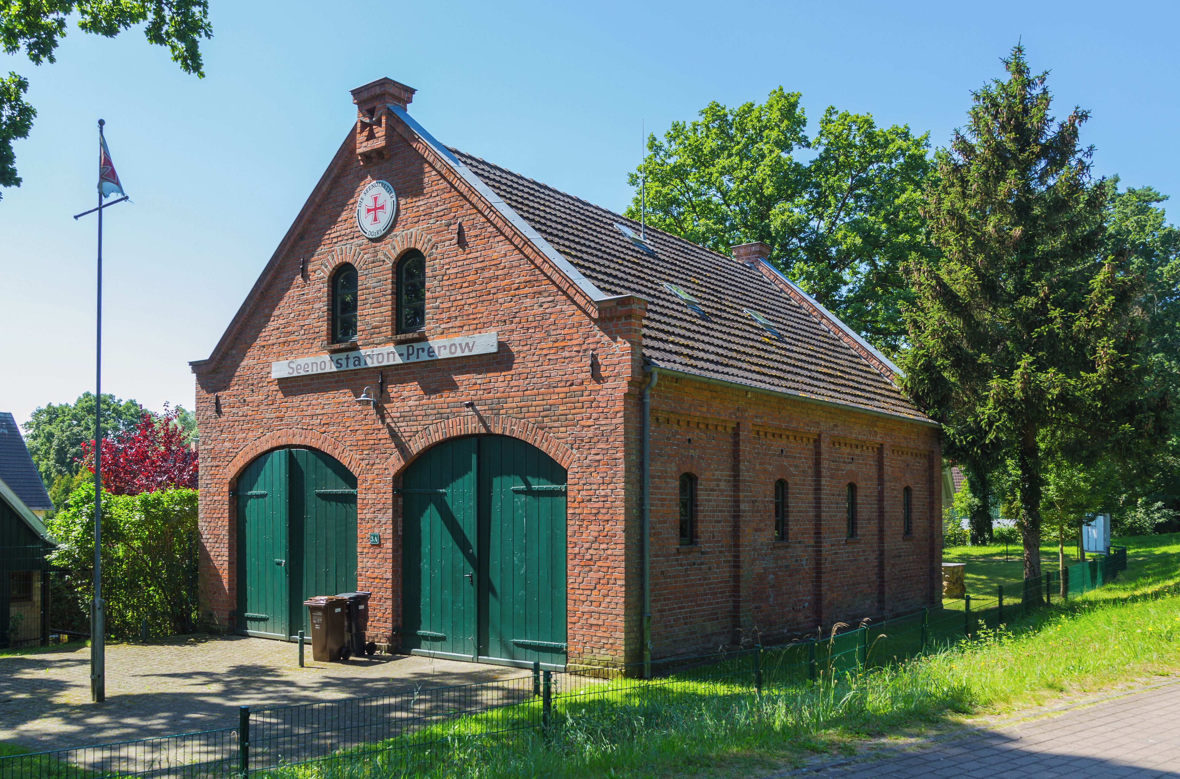 A brick building with green doors and a sign that reads "Seenstation Prerow."