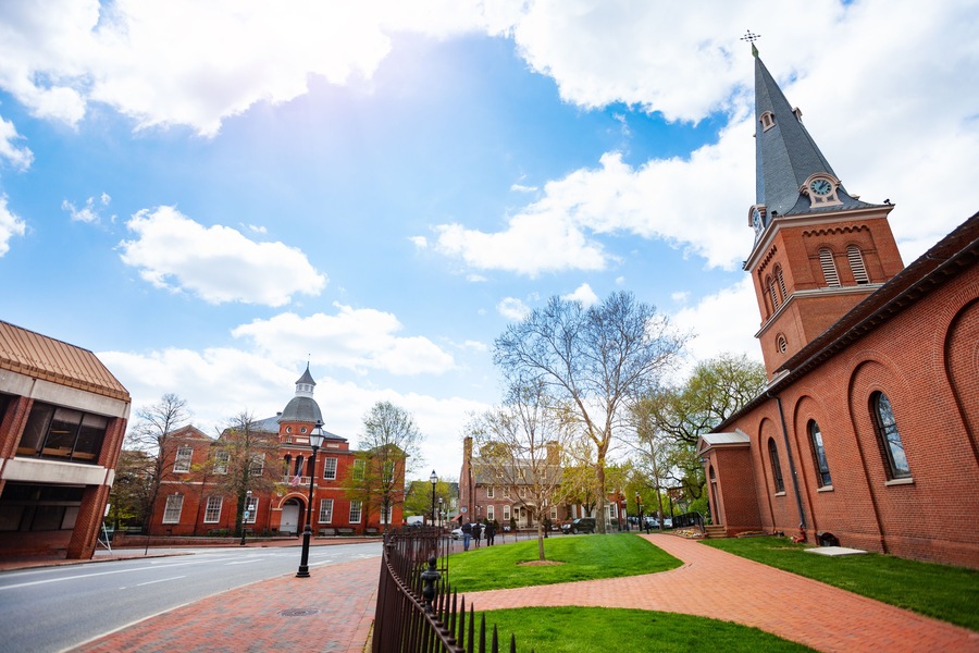 Government House and St. Anne's Parish Episcopal church in Annapolis MA with old tree branches at spring, Maryland USA