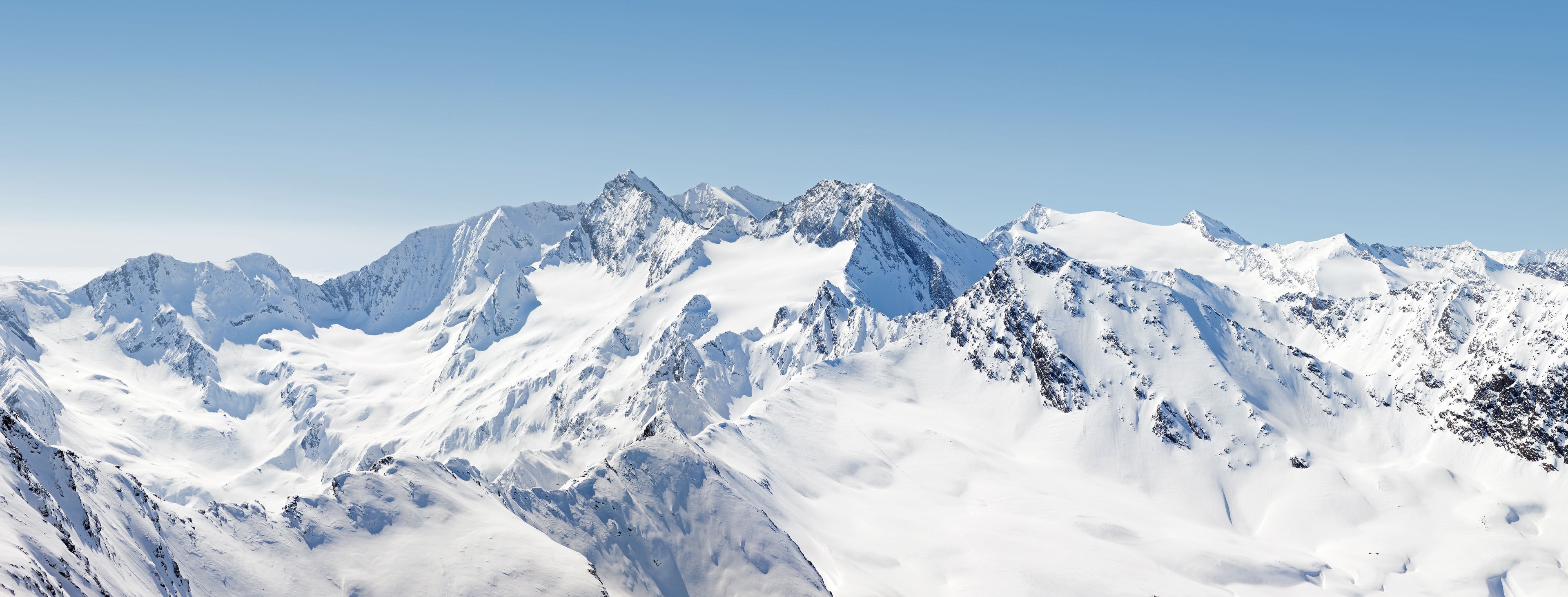 A snow-covered mountain range with sharp peaks and ridges.