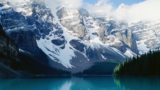 Snowy mountains with clouds and lake