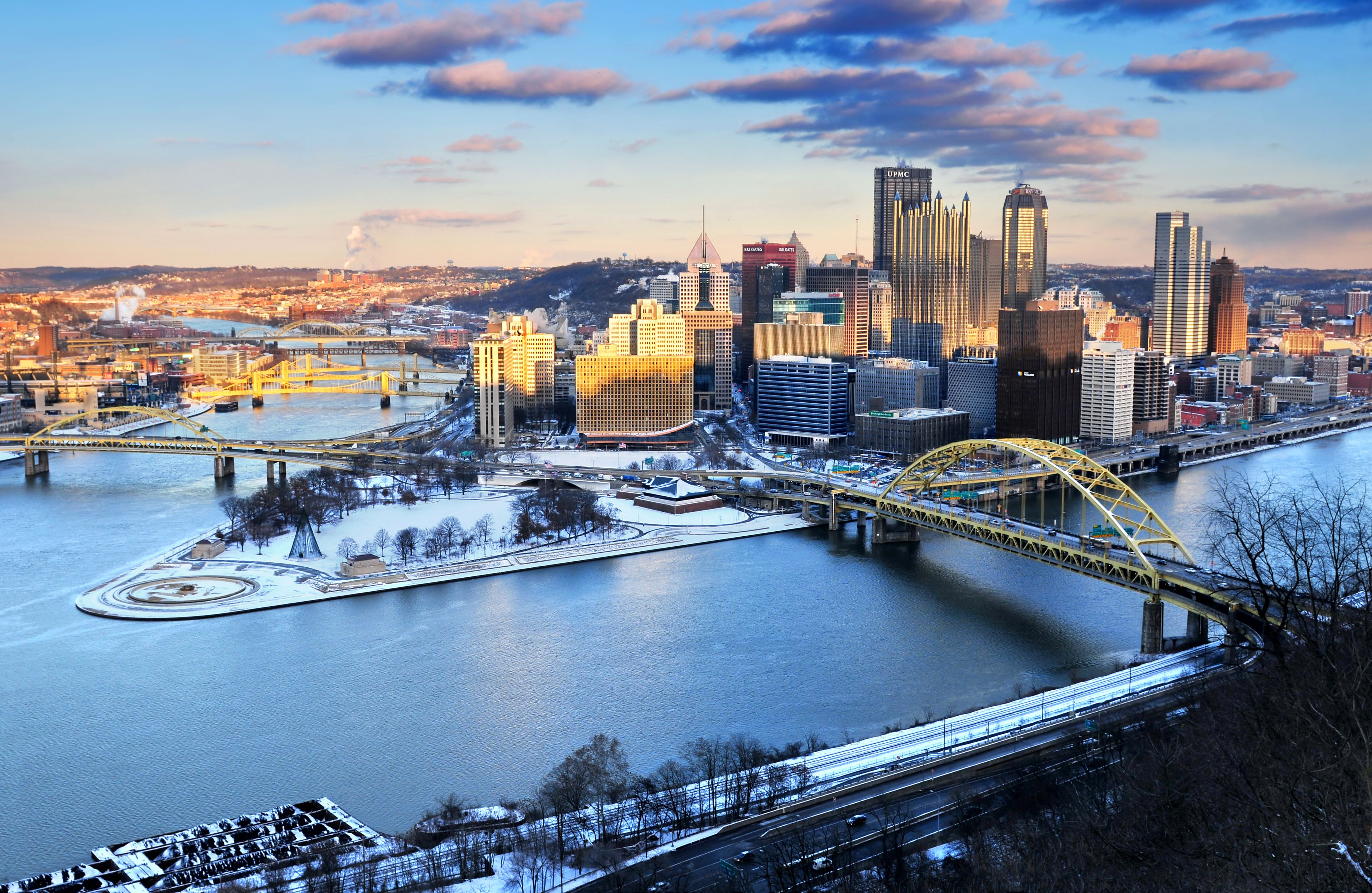A cityscape with a river, a bridge, and several skyscrapers.