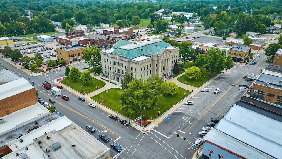 Aerial downtown Auburn Indiana courthouse with green lawn