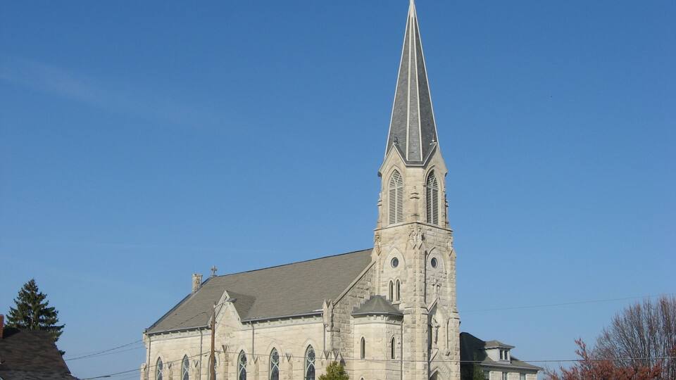 A church with a tall steeple and a sign reading "Ferguson-Lee".