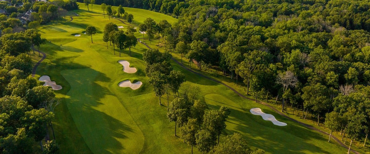 A golf course with sand bunkers and trees.