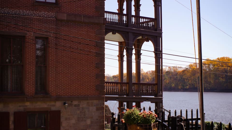 A brick building with a balcony overlooking a body of water.