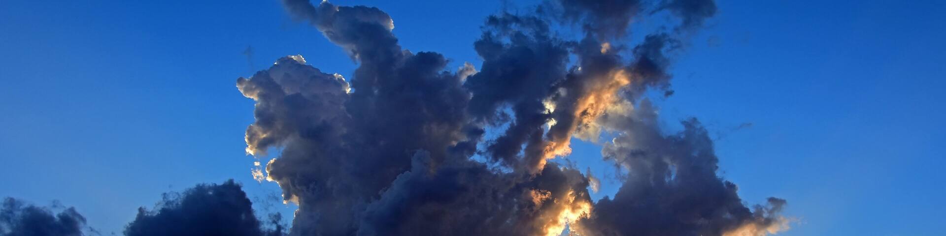 a panoramic shot of a colorful sunset over the front range of the colorado rocky mountains as seen form broomfield, colorado