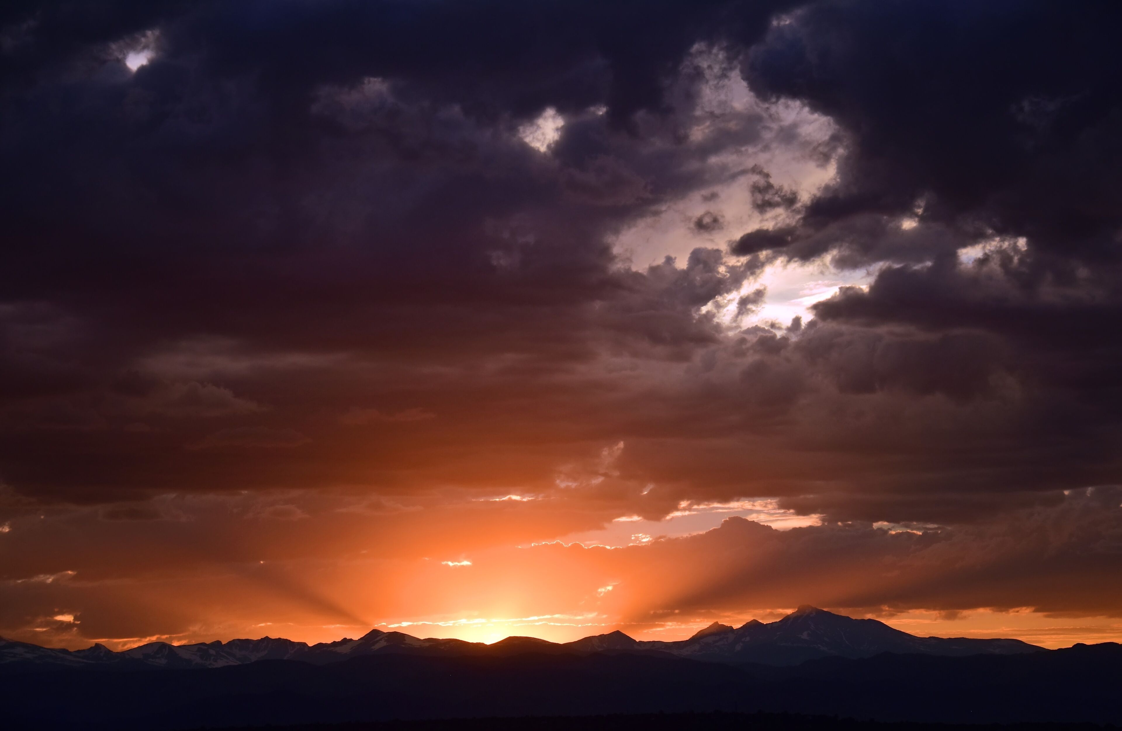 dramatic sunset over  long's peak and the front range of the colorado rocky mountains as seen from broomfield, colorado