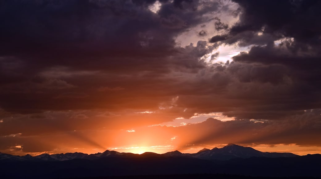 dramatic sunset over long's peak and the front range of the colorado rocky mountains as seen from broomfield, colorado