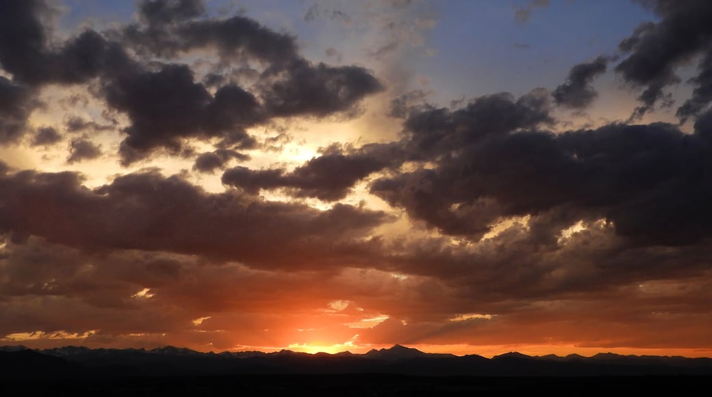 colorful sunset over long's peak, mount audobon, sawtooth mountain. and the front range of the colorado rocky mountains as seen from broomfield, colorado