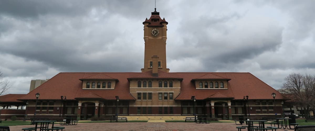A large clock tower with a red roof and an American flag atop.