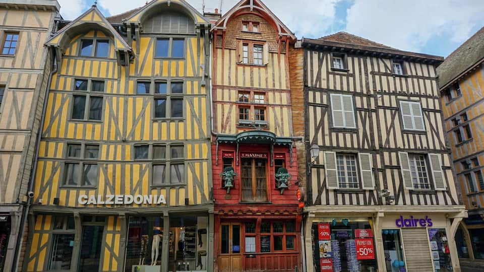 A row of traditional half-timbered buildings with storefronts, including Calzedonia and claire's.