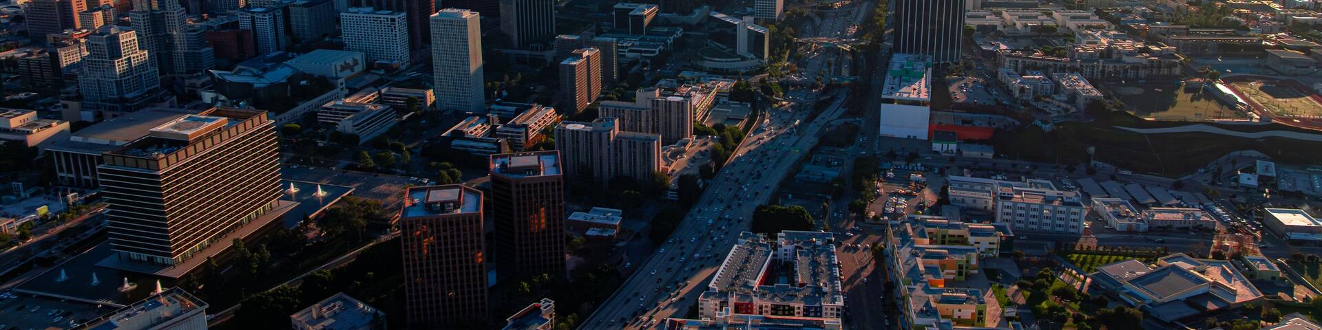 Los Angeles cityscape with freeways at sunset. Wide aerial cityscape of Los Angeles with highways glowing at sunset.