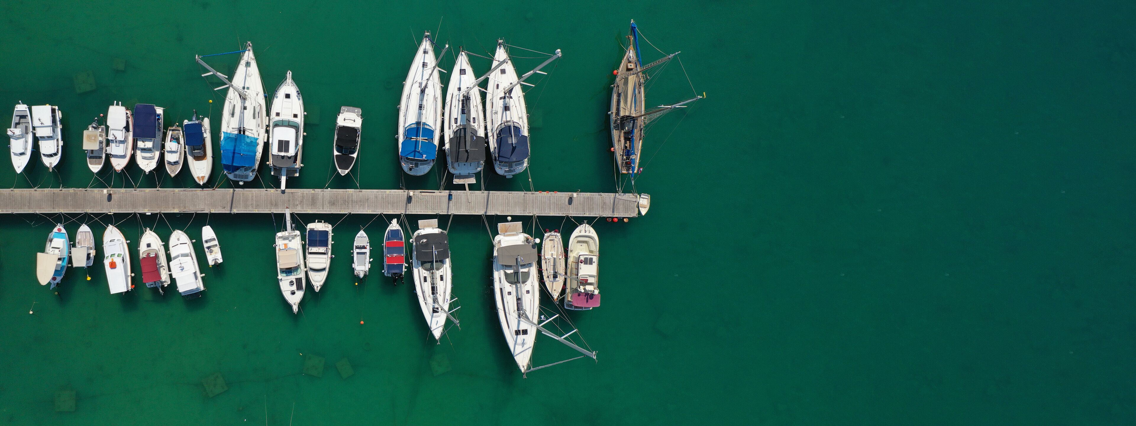 Aerial drone top down ultra wide photo of sail boats anchored in port and Marina of main town of Aegina island, Saronic gulf, Greece