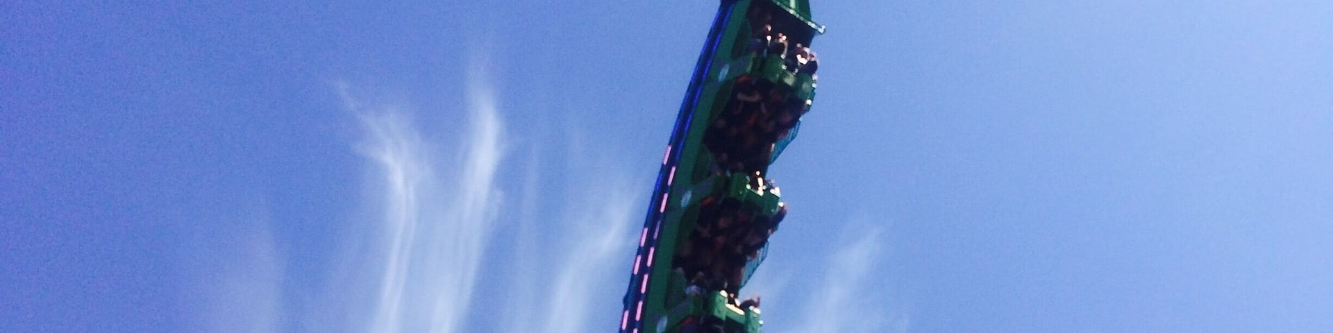 A roller coaster in a loop against a clear blue sky.