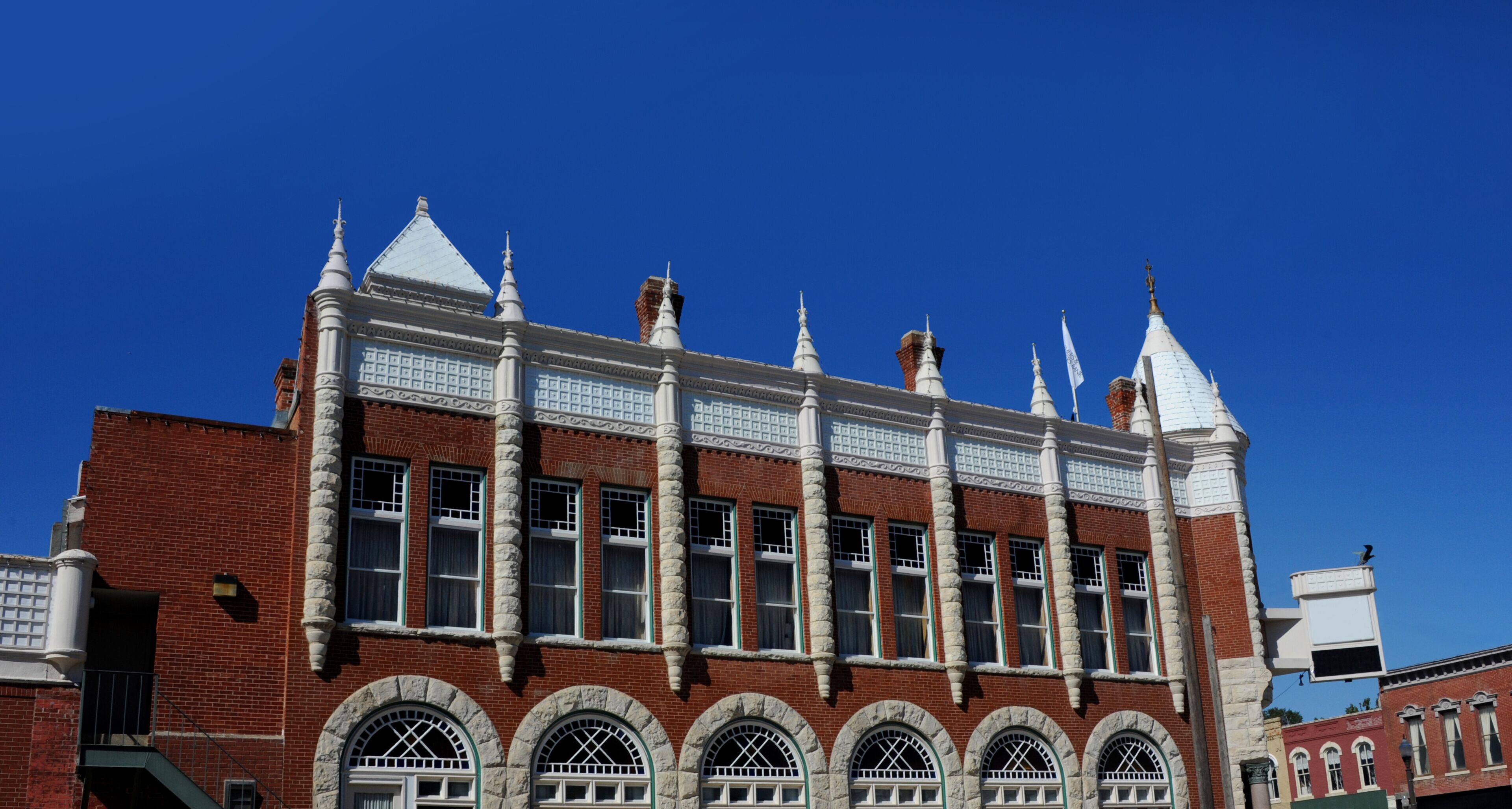 A historic building with a red brick facade, white trim, and multiple arched windows.