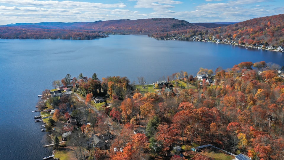 A lake surrounded by autumn-colored trees and houses.