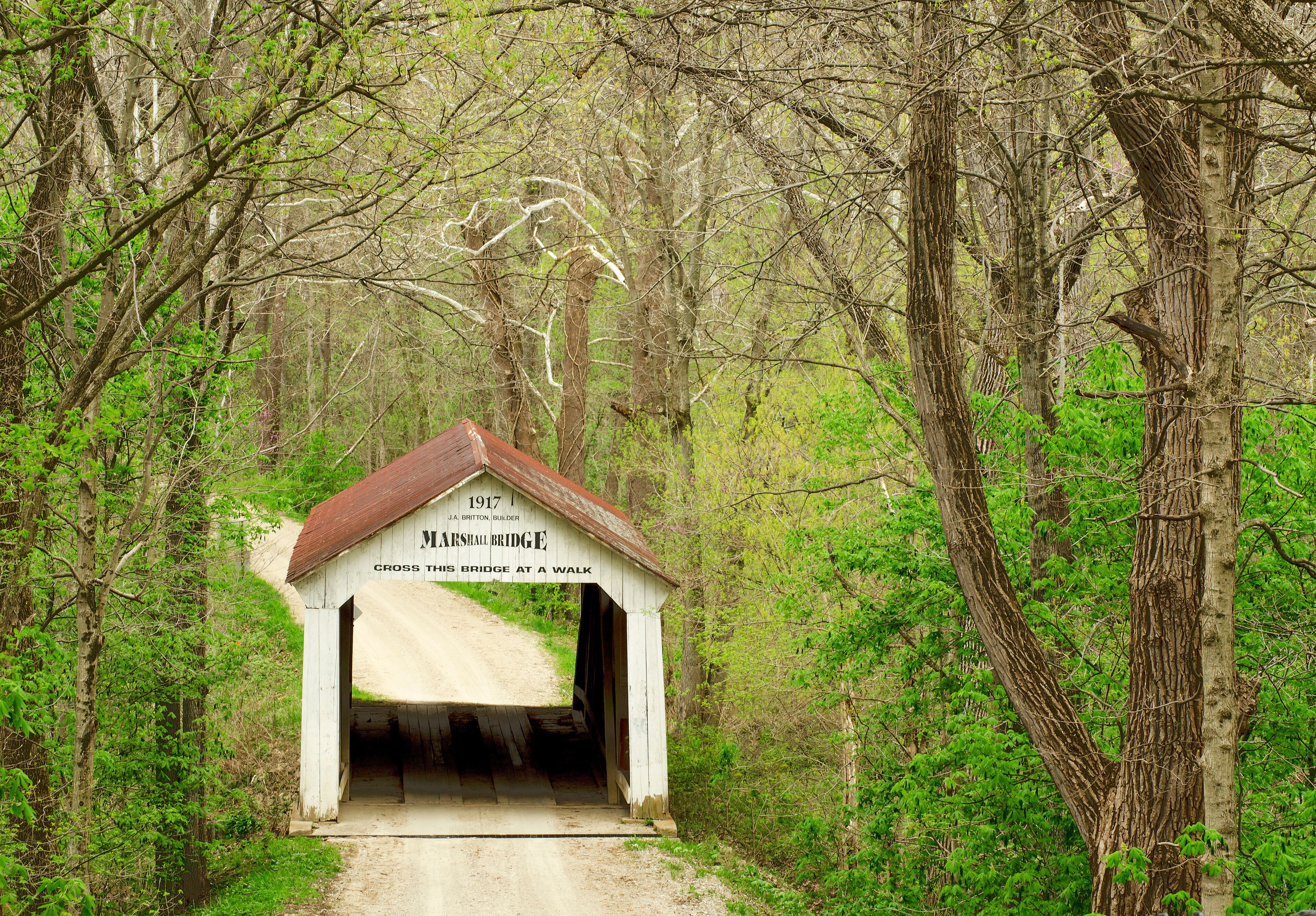 A small white bridge with a sign reading "1917 Marston's Bridge, Cross this bridge at a walk."