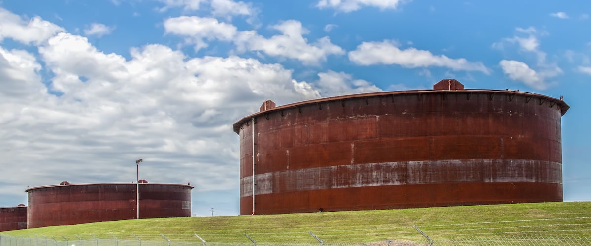 Huge rusty storage tanks full of petroleum products in tank farm in Cushing Oklahoma where most oil in USA is stored and traded